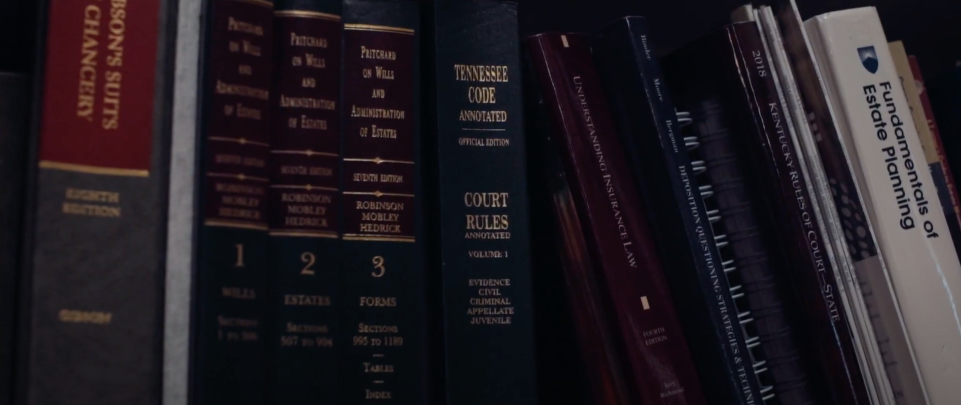 Multiple legal books on a bookshelf related to estate planning law.